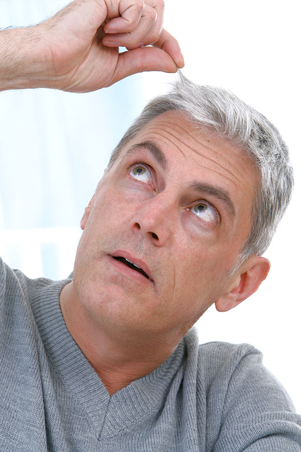 Homme avec cheveux blancs Homme qui regarde ses cheveux blancs